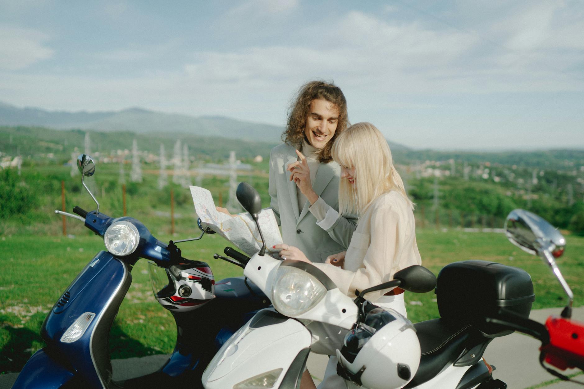 Młodzi turyści na skuterach Peugeot planują trasę na wiejskiej drodze