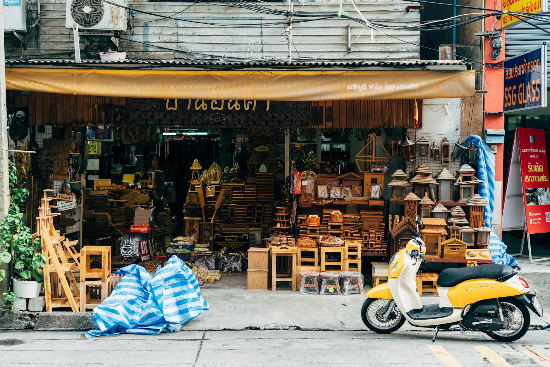 Skuter zaparkowany przed sklepem z tradycyjnymi drewnianymi wyrobami