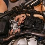 Mechanik reguluje silnik skutera Peugeot w warsztacie