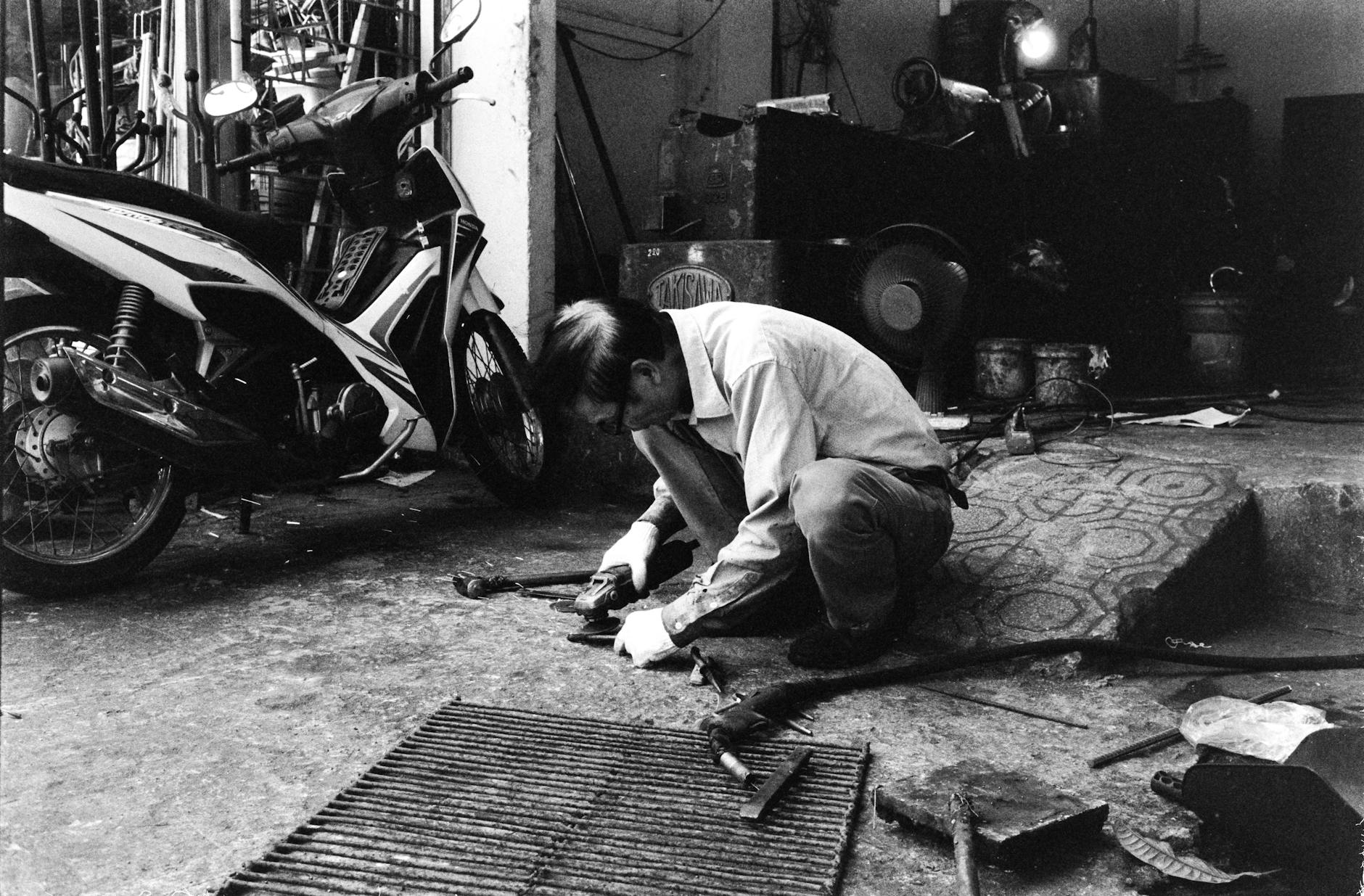 Mechanik serwisuje skuter Peugeot w warsztacie przed sezonem